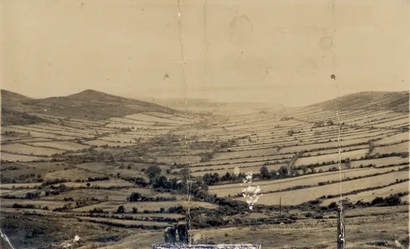 Historic view of Gleann na nGealt, with fields across the valley between the hills
