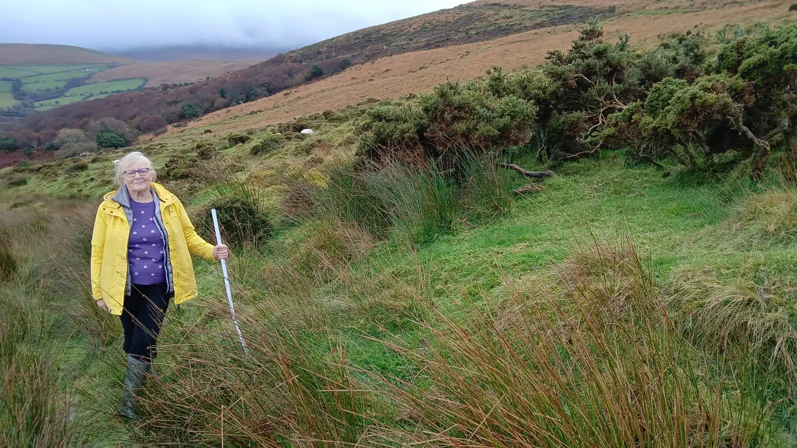 Brigid walking through the grassy valley on the family hill farm in Gleann na nGealt